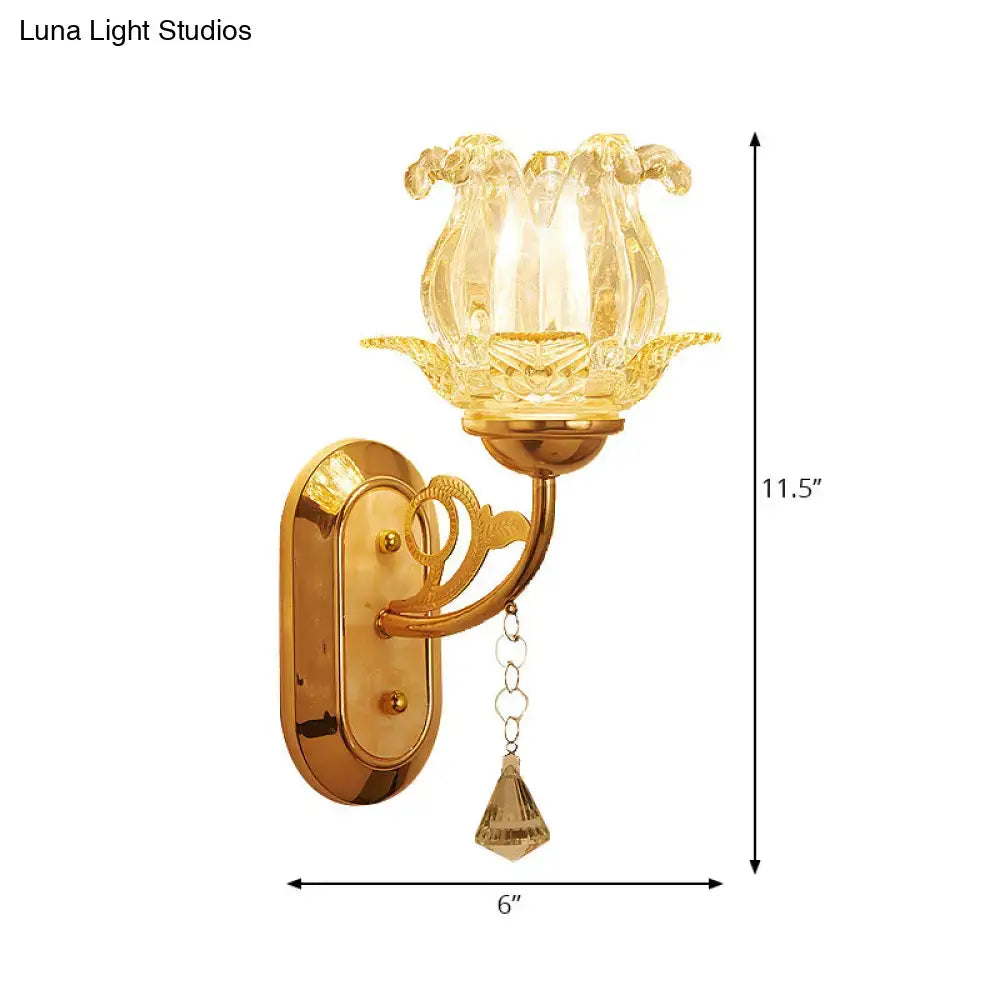Vintage gold flower wall sconce with amber glass shade shaped like a lotus and a pull chain in bedroom light