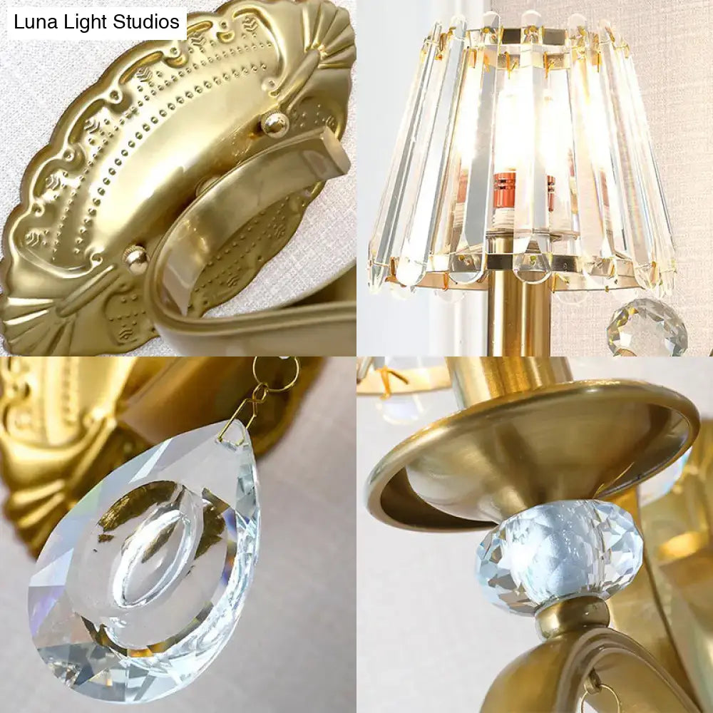 Vintage gold metallic wall lamp featuring an ornate design with crystal accents and a teardrop hanging crystal sconce