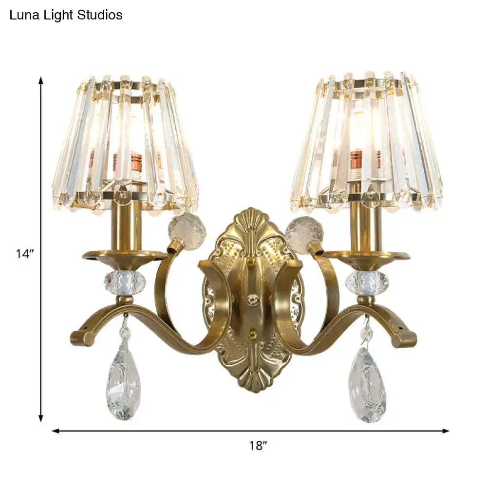 Vintage gold metallic wall lamp featuring an ornate metallic wall lamp with two crystal chandelier shades and teardrop crystals