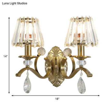 Vintage gold metallic wall lamp featuring an ornate metallic wall lamp with two crystal chandelier shades and teardrop crystals