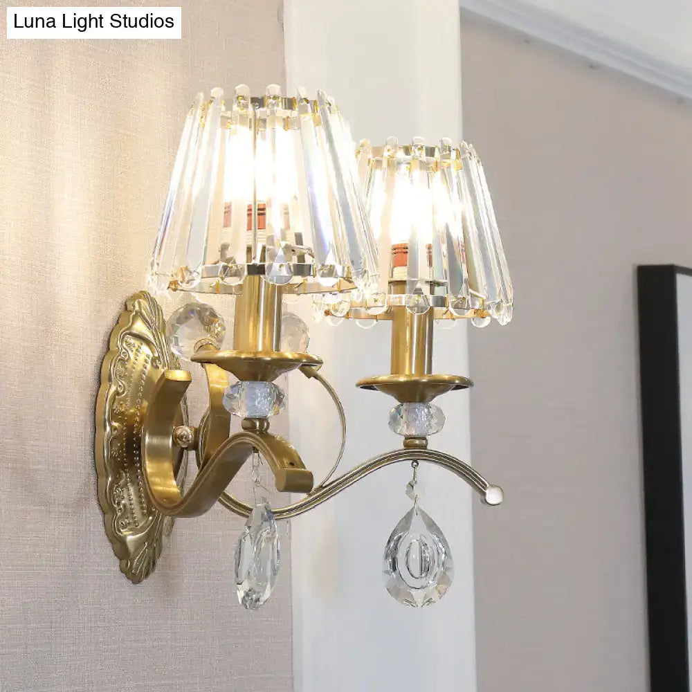 Gold metallic wall lamp with two crystal-encrusted lampshades and dangling teardrop crystals for bedroom use