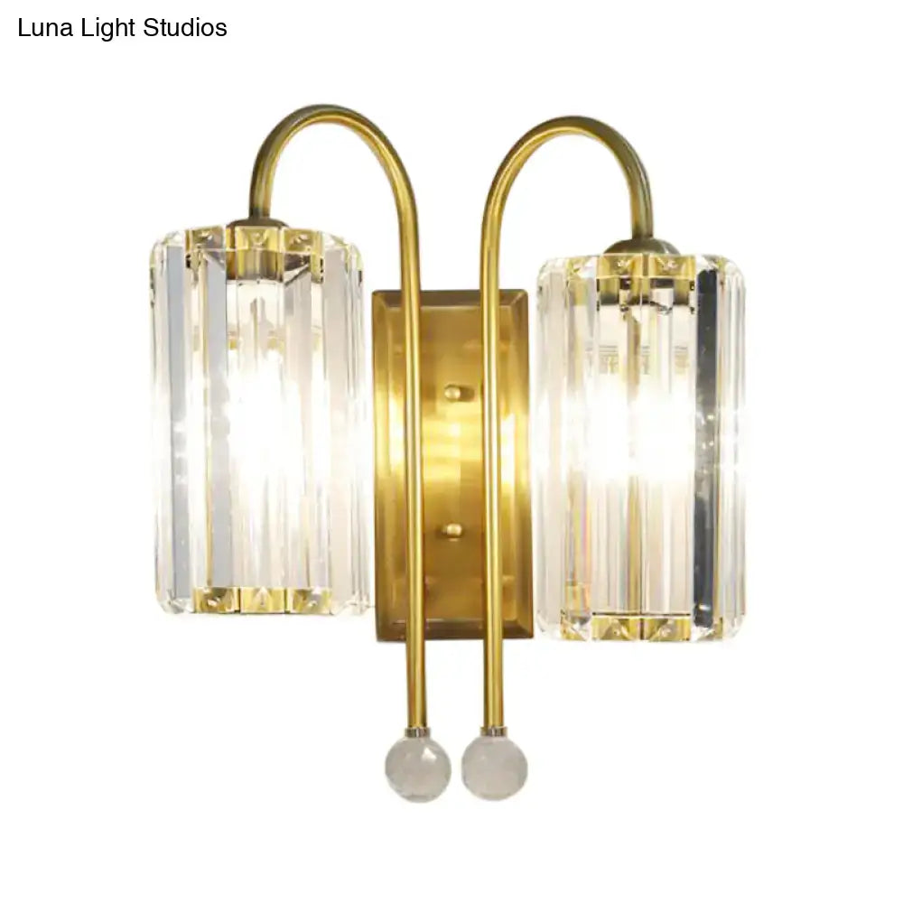 Brass-finished wall light with two vertical clear crystal shades and spherical glass accents for bedroom use