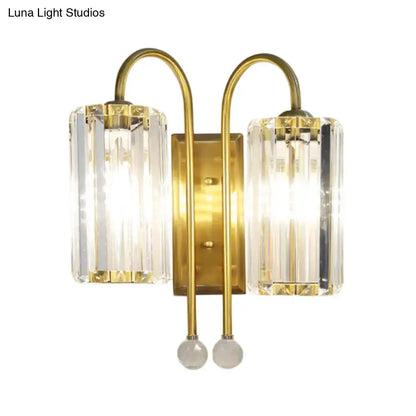 Brass-finished wall light with two vertical clear crystal shades and spherical glass accents for bedroom use
