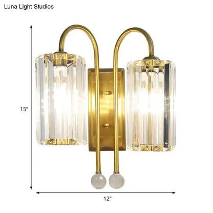 Vintage gold wall light with brass finish featuring two vertical clear crystal shades and spherical glass accents for bedroom sconce