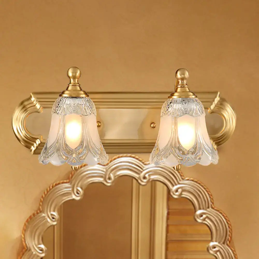 Vintage gold wall light with ornate gold-toned fixture and two frosted glass shades featuring clear glass shade patterns