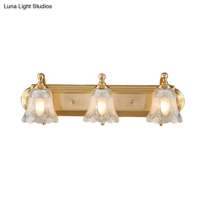 Vintage gold wall light with three clear glass shades featuring etched patterns for bathroom vanity lighting