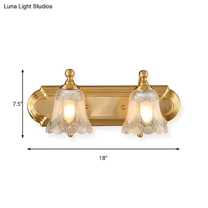 Vintage gold wall light with two ornate clear glass shade bell-shaped fixtures for bathroom vanity lighting