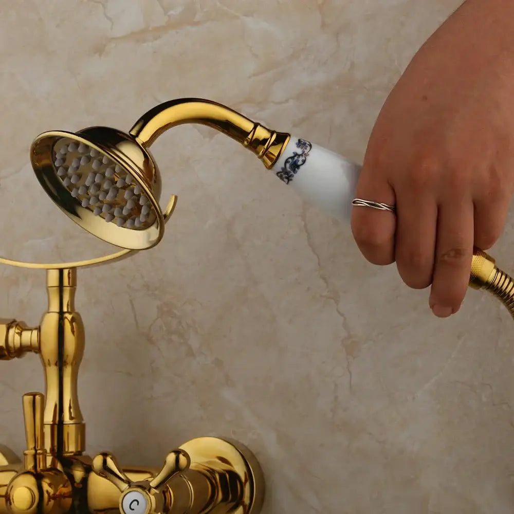 Vintage golden bathtub faucet with decorbites golden showerhead and white ceramic handle with blue floral detailing