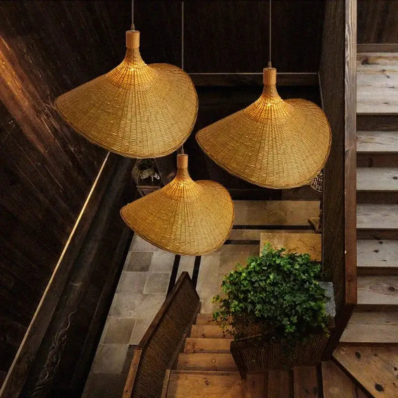 Three golden brown bamboo wicker chandelier pendant lights with a traditional conical shape for dining room use