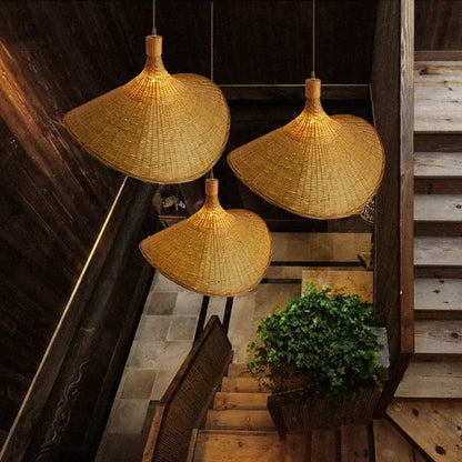 Three golden brown bamboo wicker chandelier pendant lights with a traditional conical shape for dining room use