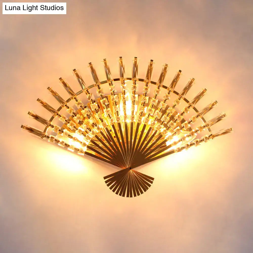 Vintage golden fan shaped sconce lamp with gold finish crystal accents and warm glowing light for living room wall