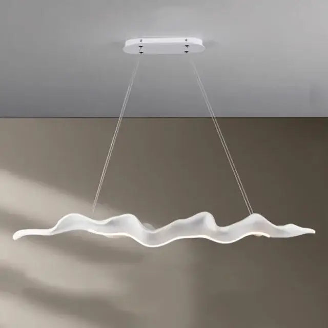 A sleek white led pendant light with a wave design complements the vintage golden leaf iron finish for dining rooms