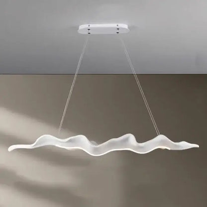 A sleek white led pendant light with a wave design complements the vintage golden leaf iron finish for dining rooms