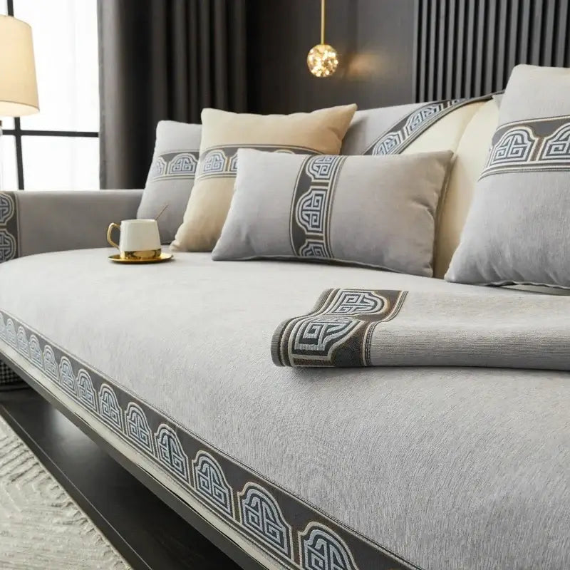 Vintage gray chenille sofa cover with blue and gold embroidery featuring a gray cushion with dark geometric border