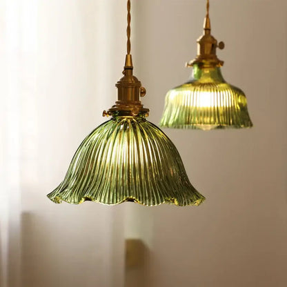 Vintage green glass pendant light with ribbed ruffled petal design and brass hardware for dining room installation