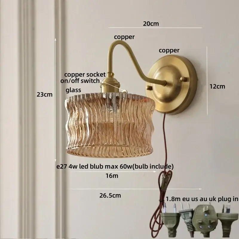 Vintage wall light with copper knob switch featuring antique brass copper and textured amber glass shade