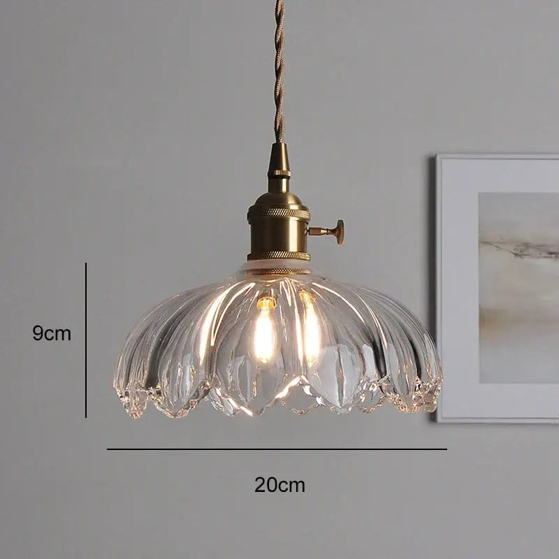 Clear ribbed glass pendant light with brass fixture and twisted cord thoughtfully styled for dining room use