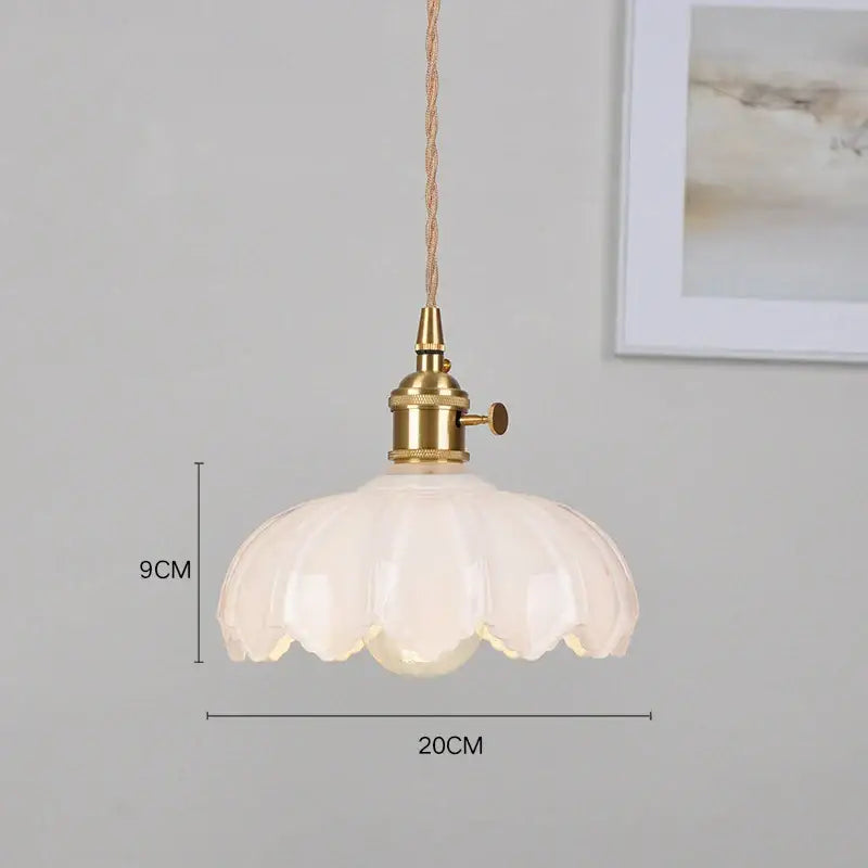 Delicate white glass pendant light with brass fixture and twisted cord thoughtfully styled for dining room use