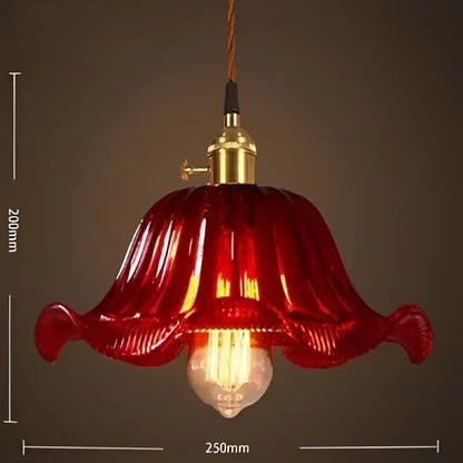 A vibrant red petal-shaped glass pendant light with brass fixture and exposed bulb for vintage living room pendant lights