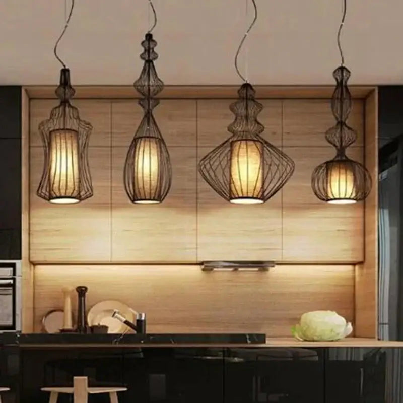 Four elegant black wire decorbites birdcage chandelier pendant lights with warm paper shades in modern kitchen