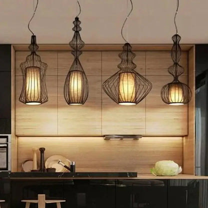Four elegant black wire decorbites birdcage chandelier pendant lights with warm paper shades in modern kitchen