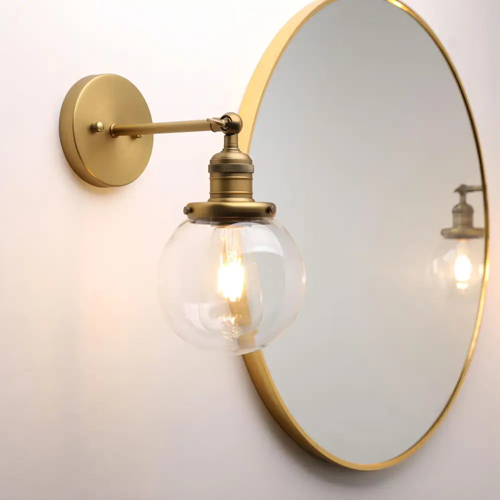 Brass-finished vintage industrial wall sconce with clear glass globe and exposed filament bulb for bedroom decorbites vintage industrial decor
