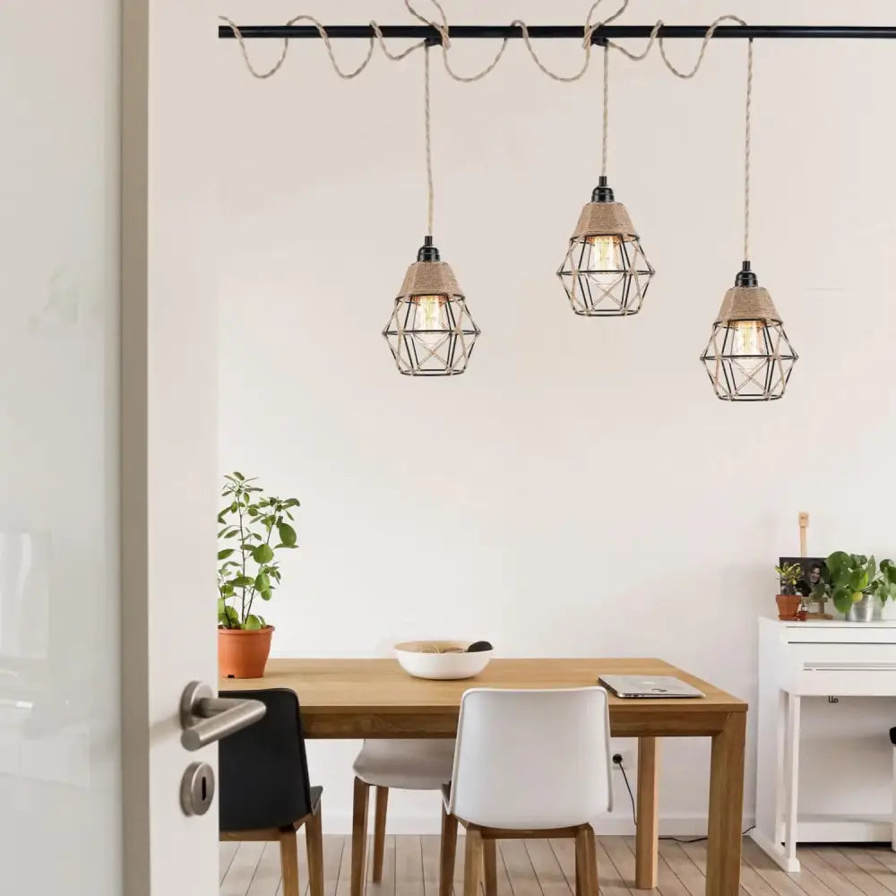 Three vintage industrial pendant lights with black metal cages and beige hemp rope shades hang on a black track