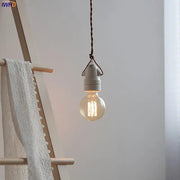 A warm-toned vintage industrial matte white ceramic led pendant lamp with decorbites ceramic led bulb hanging from twisted cord