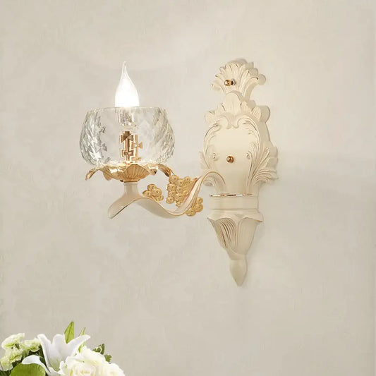 Elegant vintage ornate cream and gold wall light sconce with faceted crystal glass shade for bedroom lighting