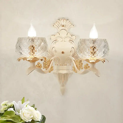 Elegant cream and gold vintage wall light sconce with two faceted crystal glass shades for bedroom use