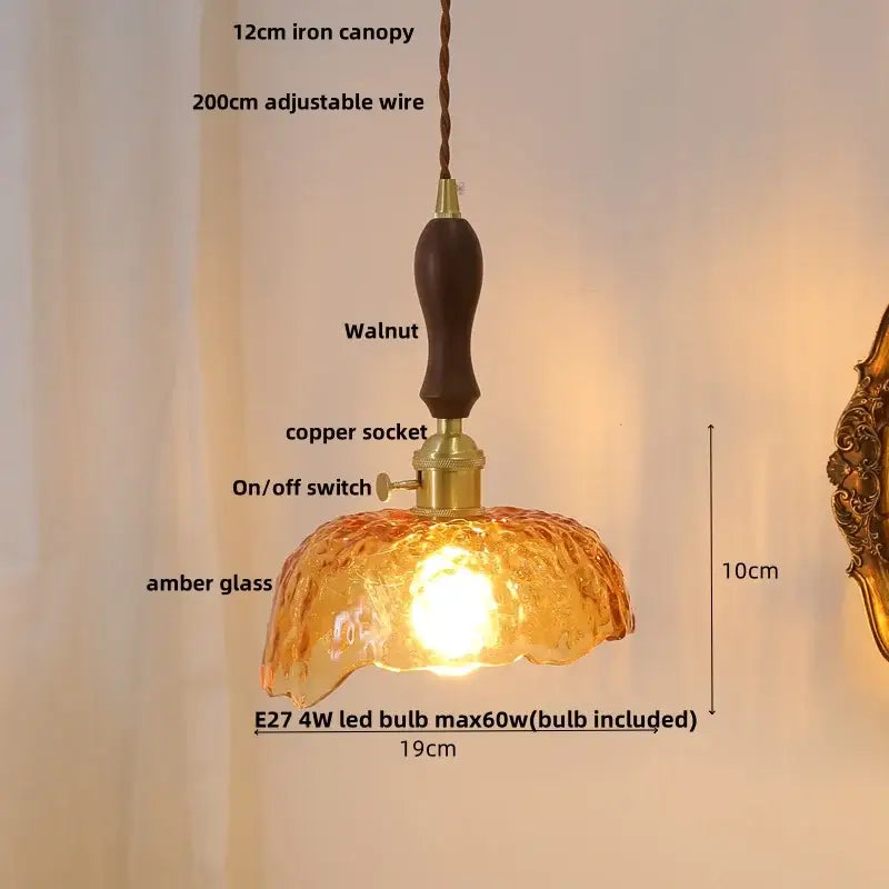 Warm amber glass pendant light with dark walnut handle and brass accents featuring decorbites ceramic knob switch