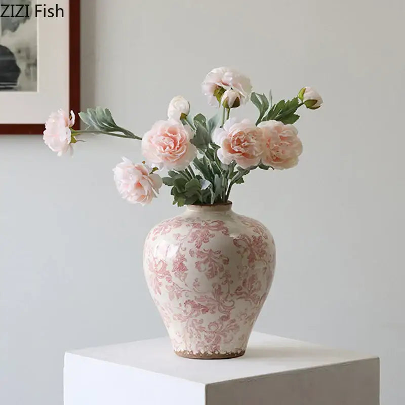 A delicate cream ceramic vase with a subtle pink floral cracked texture holding blush peonies for living room decor