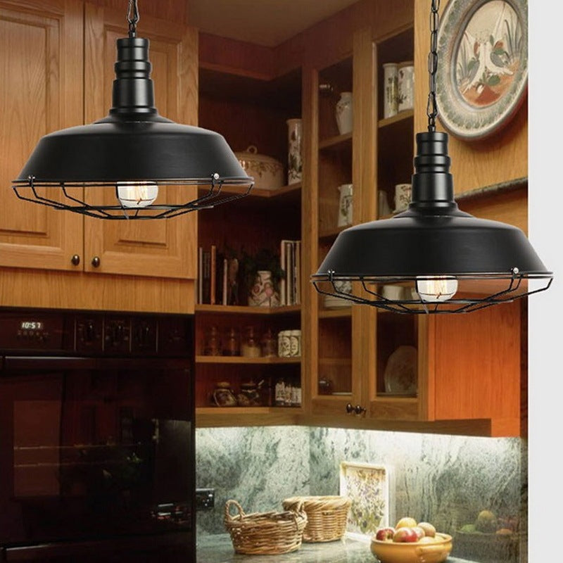 Black industrial pendant light with metal cage design and hanging cords, suitable for kitchen or dining room.