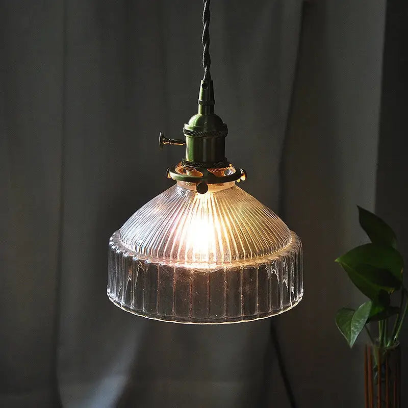 Vintage clear ribbed glass pendant light with dark green metal fixture and copper accents for dining room use