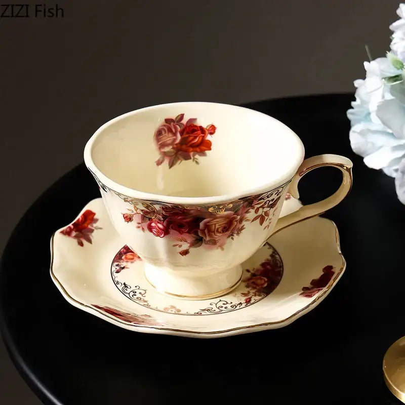Cream-colored porcelain coffee mug with red rose patterns and gold trim in a vintage dining room set