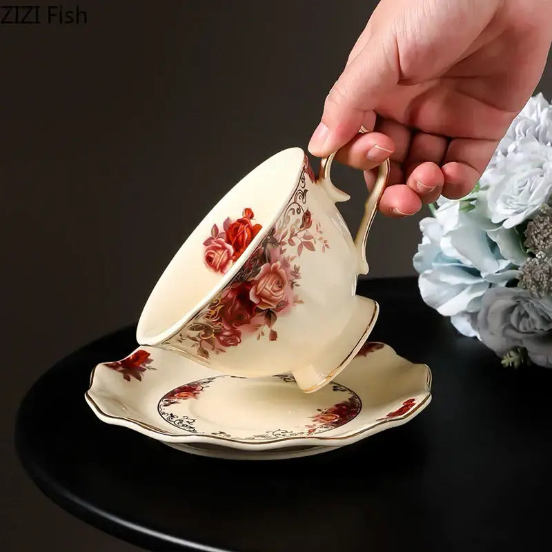 Cream-colored porcelain coffee mug with red and pink rose design and gold-trimmed handle and rim for dining room use