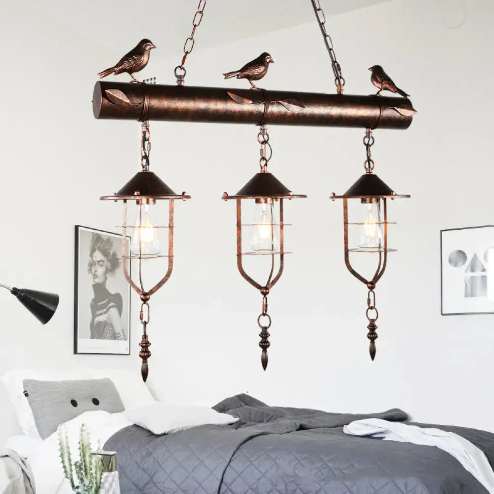 Copper-toned DecorBites vintage metal island lighting with three caged shade bulbs and decorative bird element rust finish