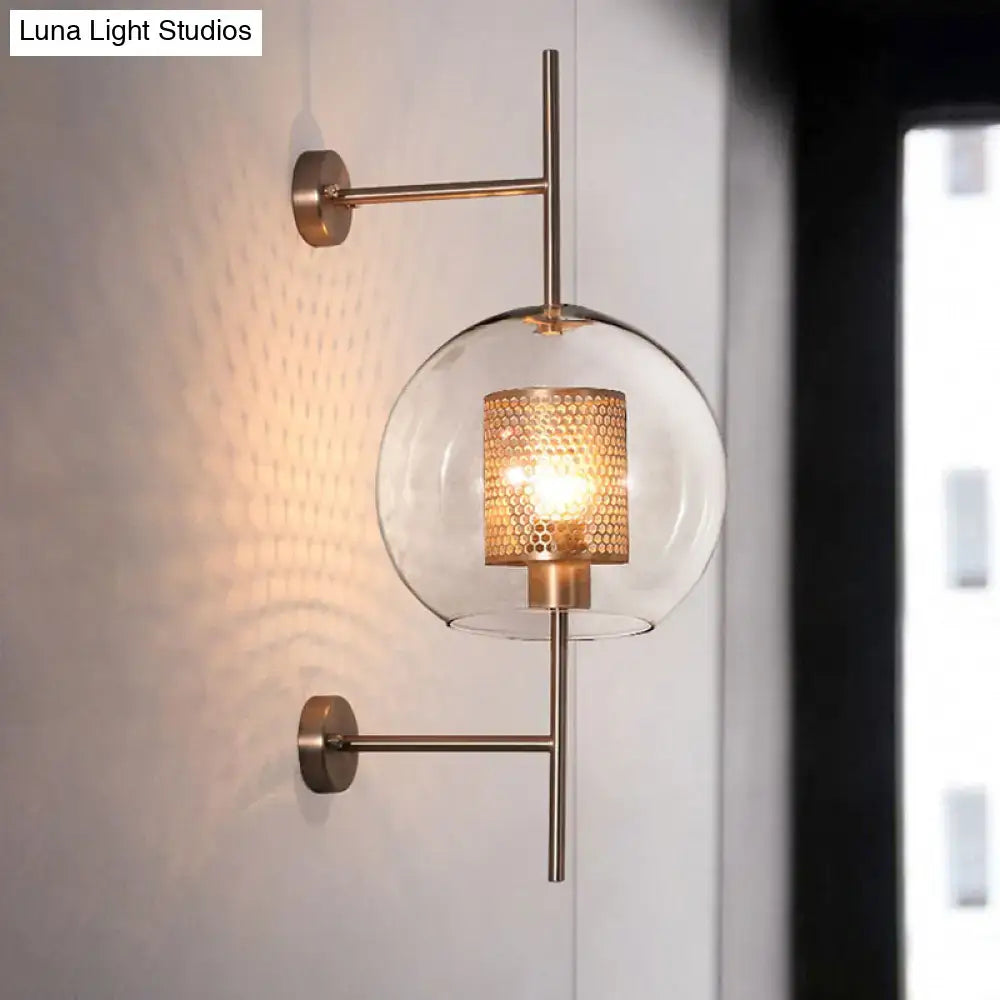 A vintage silver and gold modern clear glass sconce light with brass and amber honeycomb-patterned shade for bedroom wall