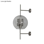 Modern vintage silver and gold clear glass sconce light with perforated metal shade and brushed nickel arms for bedroom walls