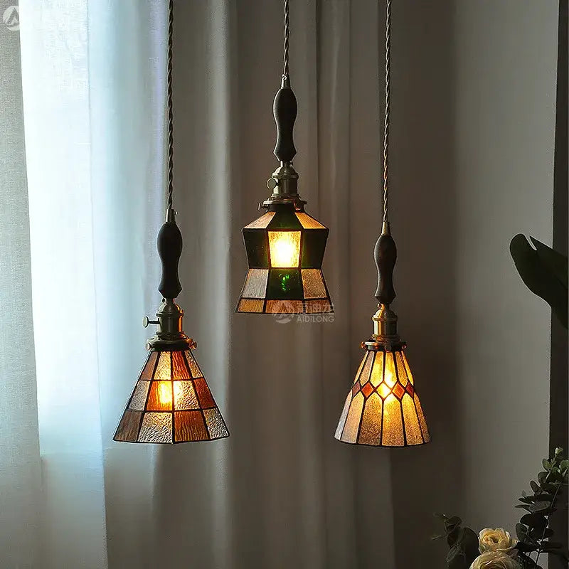 Three vintage pendant lights with stained glass copper shades amber green hues brass hardware and wood knob switch