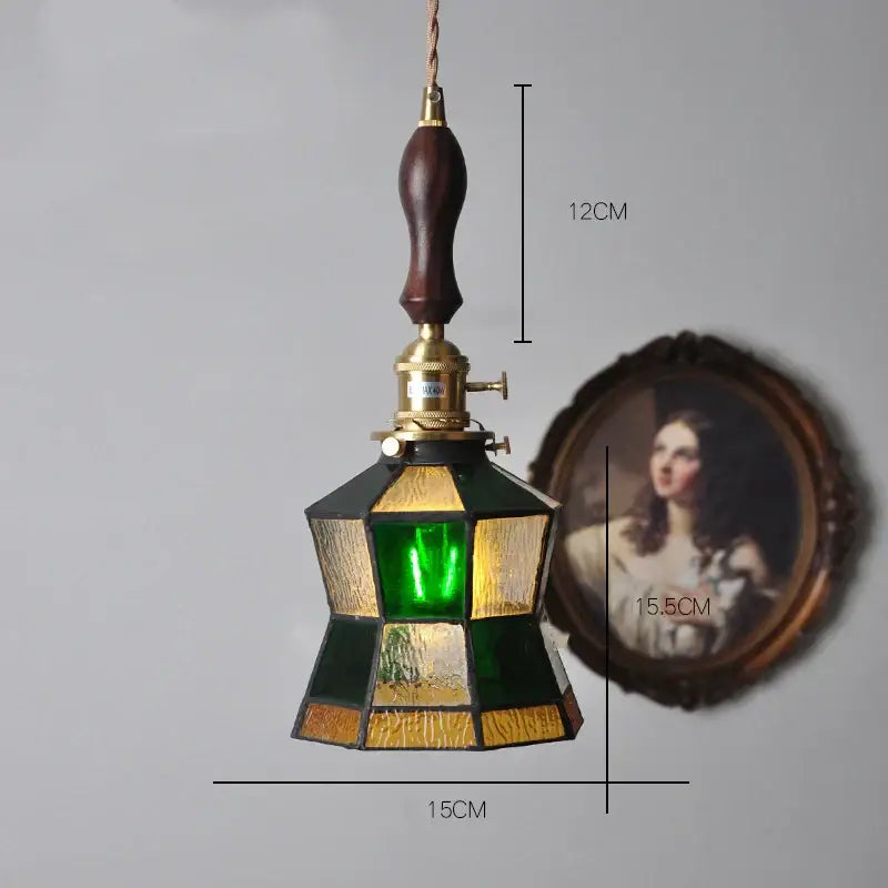 Vintage stained glass copper pendant light with green and amber panels featuring a wood knob switch for kitchen use