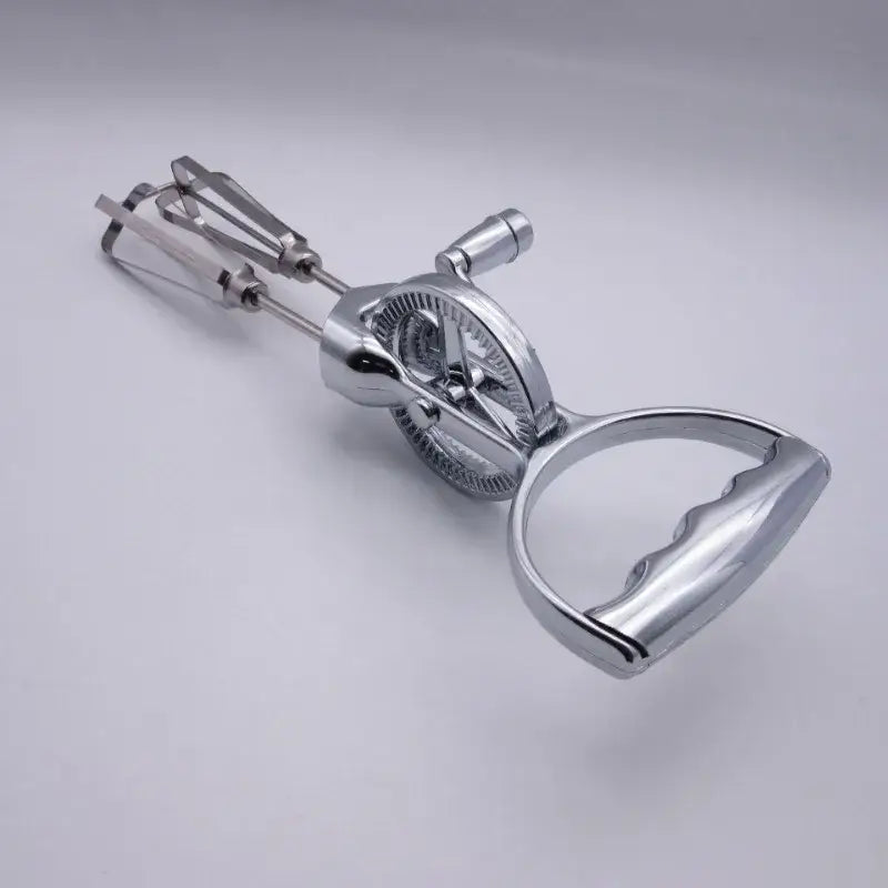 Vintage stainless steel egg beater with shiny chrome finish curved handle and dual beater balloon whisk attachments