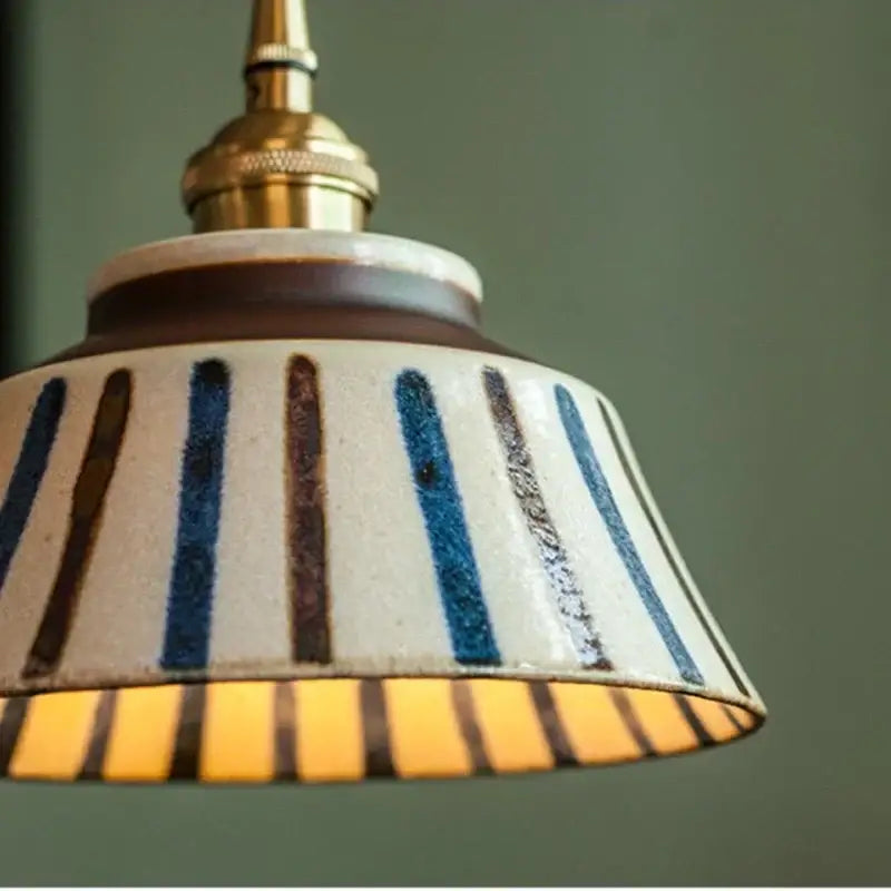 Vintage pendant light with vertical blue and brown stripes on cream ceramic base and brass fixture decorbites coloured glaze