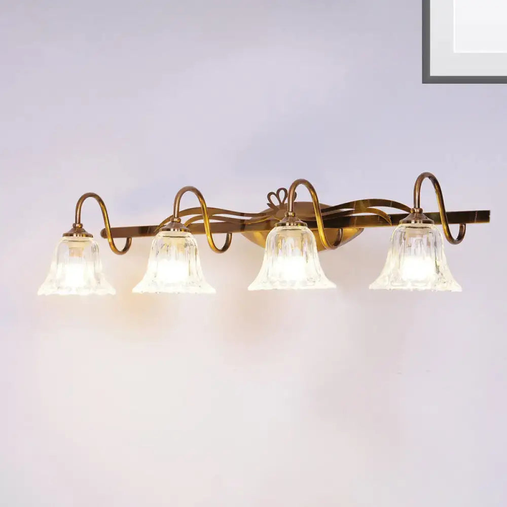 Vintage style wall light with brass finish and four clear bell-shaped glass shades for bathroom vanity use