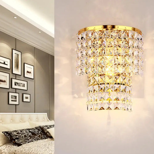 Vintage style wall sconce with gold tone and tiered faceted clear crystals in a cascading design for bedroom light