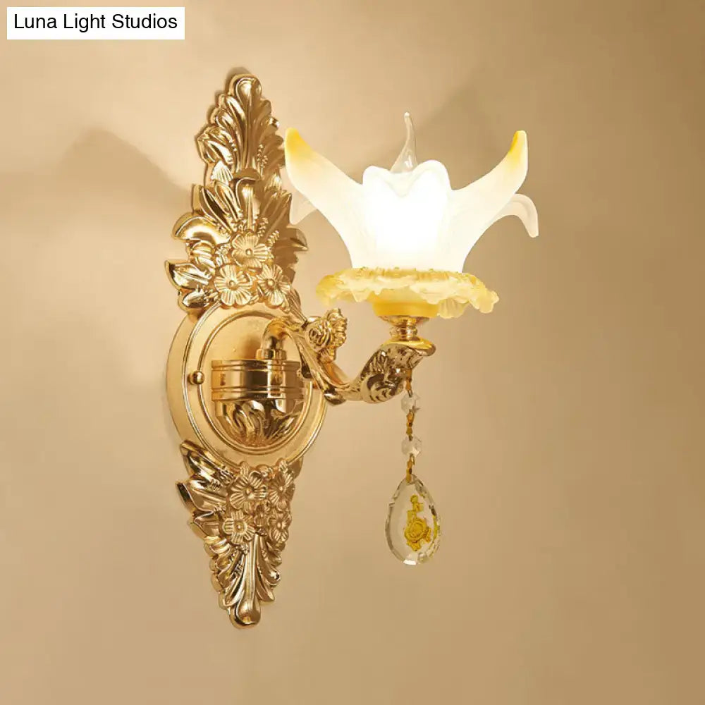 Vintage style wall light with gold-tone ornate metal, opal glass flower shade, and crystal teardrop pendant for bedroom