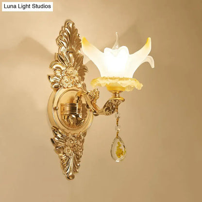 Vintage style wall light with gold-tone ornate metal, opal glass flower shade, and crystal teardrop pendant for bedroom
