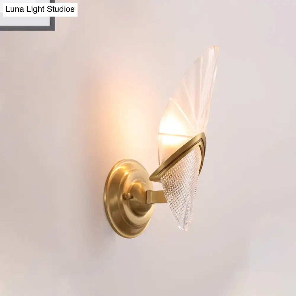 Vintage style wall lamp with brass finish and frosted glass fan-shaped shade featuring intricate etched patterns