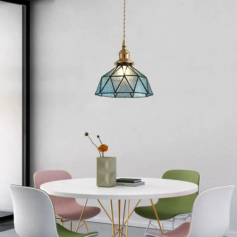 Vintage teal blue glass led pendant light with a brass finish hanging from a twisted cord for decorbites blue glass