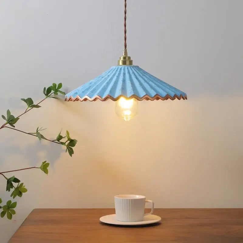 A charming light blue scalloped-edge decorbites ceramic led pendant light with brass fixture and twisted cord